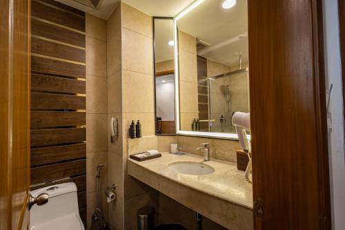 a bathroom with a sink and a mirror at The BellaVista Hotel Chandigarh Panchkula in Chandīgarh