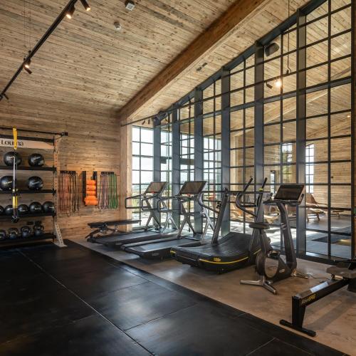 a gym with a row of treadmills and ellipticals at Louma Country Hotel in Wootton Fitzpaine
