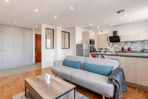 un salon avec un canapé et une cuisine dans l'établissement Sublime Appartement Villeurbanne, à Villeurbanne