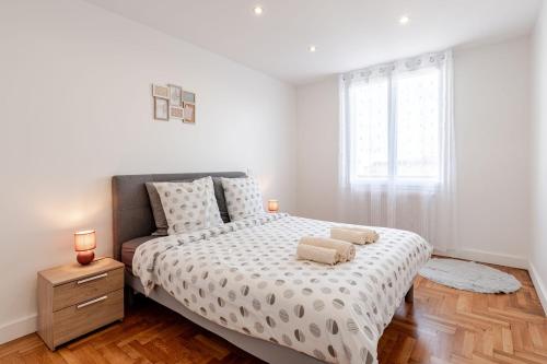 une chambre avec un lit avec deux serviettes dessus dans l'établissement Sublime Appartement Villeurbanne, à Villeurbanne