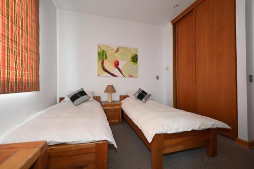 two twin beds in a room with white walls at Casa Farellones in Farellones