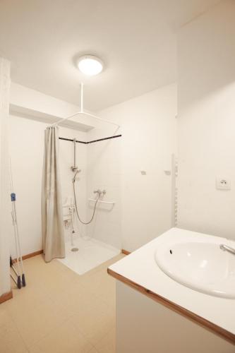 une salle de bain blanche avec un lavabo et une douche dans l'établissement Balcons C 002 PARC NAT VANOISE studio 6 pers, à Val Cenis
