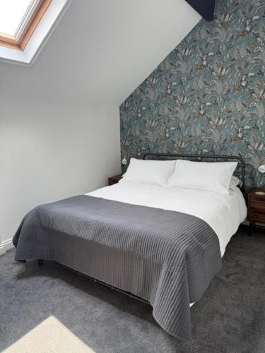 a bedroom with a large bed with a wall at Room above the Inn in Bristol