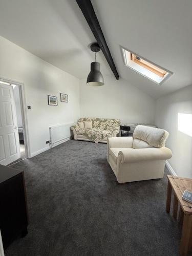 a living room with a couch and a chair at Room above the Inn in Bristol