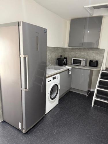 a kitchen with a refrigerator and a washing machine at Room above the Inn in Bristol
