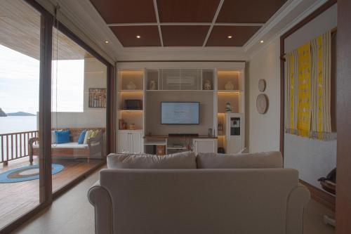 a living room with a couch and a television at Plataran Komodo Resort & Spa - CHSE Certified in Labuan Bajo