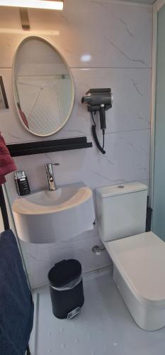 a bathroom with a sink and a mirror and a toilet at Dome Bally Kampia in Kambiá