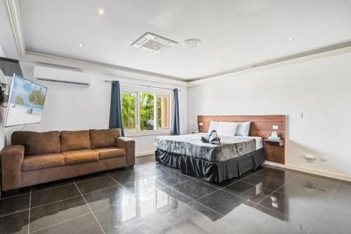 a bedroom with a bed and a couch at La Casa Piu Bella where the customer is king in Palm-Eagle Beach