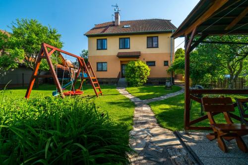 a yard with a playground in front of a house at Penzion Na Vyhlídce in Lukov