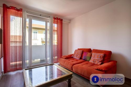 un salon avec un canapé rouge et une table en verre dans l'établissement Apartment neighborhood Liberation, à Nice
