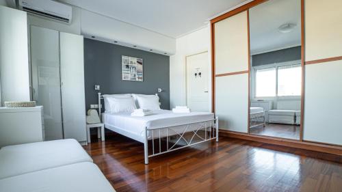 a bedroom with a white bed and a large window at Seaside Grey Pearl Villa in Piraeus