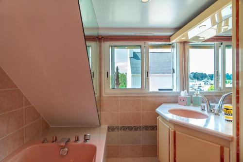 a bathroom with a pink tub and a sink at Gwell Ar Ster - Maison à 400 m de la plage in Bénodet