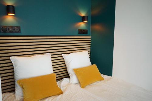- une chambre avec un lit et 2 oreillers jaunes dans l'établissement Pop Appart - Expo Paris Porte de Versailles - Balcon - Climatisation - Parking, à Paris
