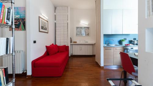 a living room with a red couch and a kitchen at Italianway - Tadino 1 A in Milan