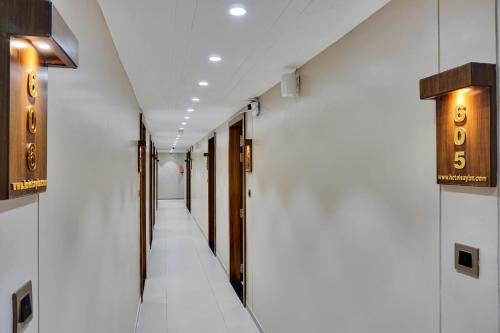 a corridor of a building with white walls at Hotel Sayba International in Pune