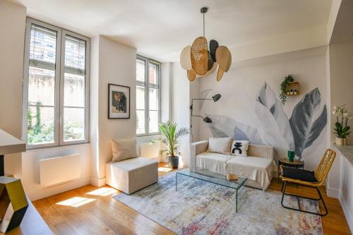 un salon avec un canapé et une chaise dans l'établissement Le Sainte - Appart 1 ch Vieux-Port hypercentre, à Marseille