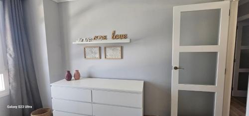 a white room with a white dresser and a door at C&C Suites in Los Llanos de Aridane