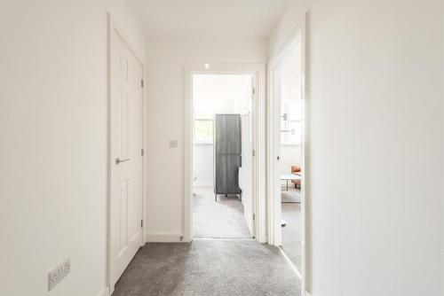 an empty hallway with white walls and a doorway at Thornhill House by Guestz in Wakefield