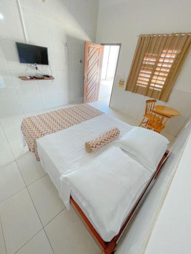 a bedroom with a bed and a television in it at Pousada o Èdio in Beberibe