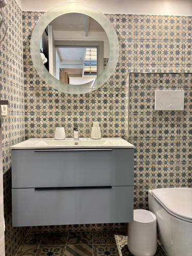 a bathroom with a white sink and a mirror at S'O Smart B&B Tropea in Tropea