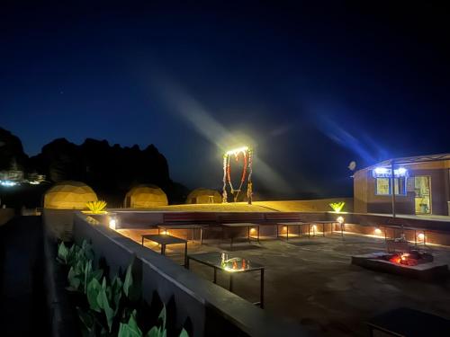 a night view of a patio with a roller coaster at Wadi Rum Legend Luxury Camp in Wadi Rum