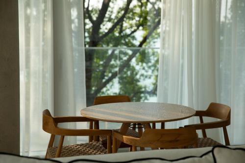 a table and chairs in front of a window at Green Cape Botanico in Batumi