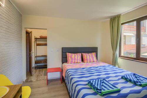 a bedroom with a bed with blue and white sheets and a window at Globus Kiten in Kiten