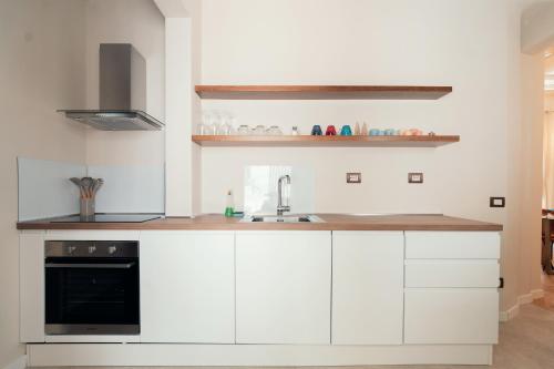 a kitchen with white cabinets and a sink at Casa mia Navona Rooms in Rome