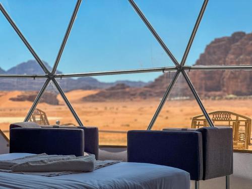 a room with two beds and a view of the desert at Wadi Rum Legend Luxury Camp in Wadi Rum