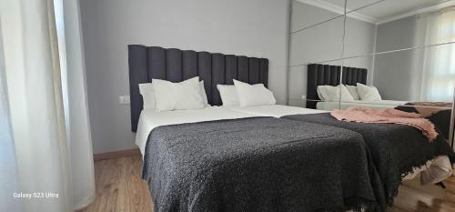 a bedroom with a large bed with a black headboard at C&C Suites in Los Llanos de Aridane