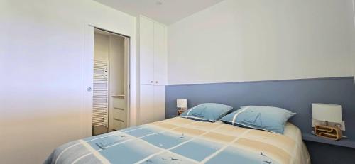 - une chambre avec un grand lit et 2 oreillers bleus dans l'établissement Élégance, Mer et Thalasso à 2 pas, à Quiberon