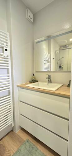 une salle de bain avec un lavabo et un miroir dans l'établissement Élégance, Mer et Thalasso à 2 pas, à Quiberon