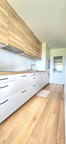 une cuisine avec des armoires blanches et un plancher en bois dans l'établissement Élégance, Mer et Thalasso à 2 pas, à Quiberon