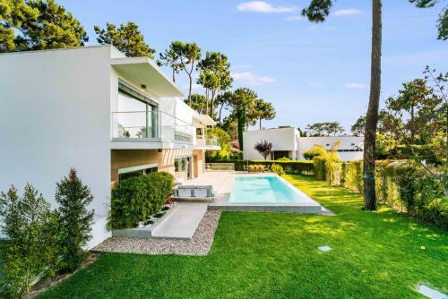 a house with a swimming pool and a yard at Luxury 4BR Villa w/ Pool & Cinema Golf | By Airnest in Aroeira