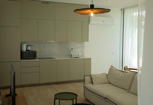 a living room with a couch and a kitchen at Green Cape Botanico in Batumi