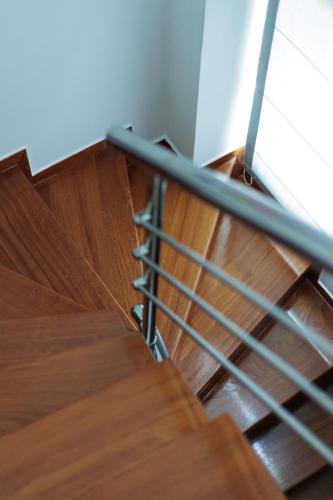 a staircase with a metal railing and wooden floors at Seaside Grey Pearl Villa in Piraeus