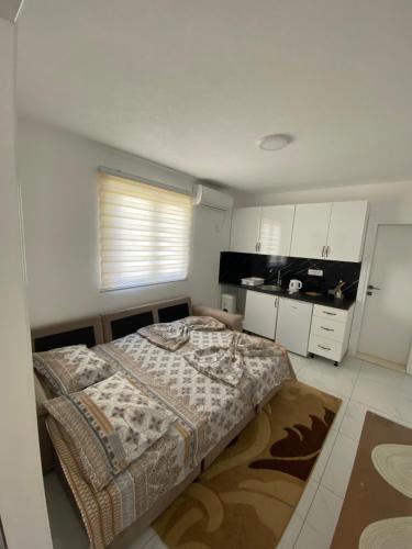 a small bedroom with a bed and a kitchen at Apartmani AMAN in Dobra Voda