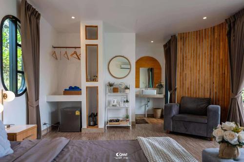 a bedroom with a couch and a chair in a room at ภูสกาย โฮมสเตย์ in Mon Jam