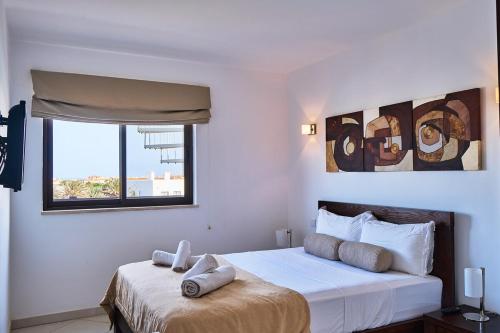 Elegant 1-Bedroom Duplex Apartment في سانتا ماريا: غرفة نوم بها سرير أبيض كبير ونافذة