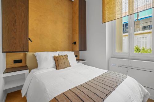 une chambre avec un lit blanc et une fenêtre dans l'établissement Élégant situé proche du palais, à Cannes