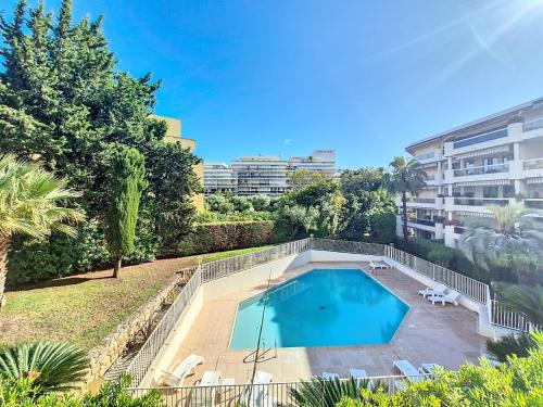 une image d'une piscine en face d'un bâtiment dans l'établissement L'Écrin de la Rostagne, à Antibes