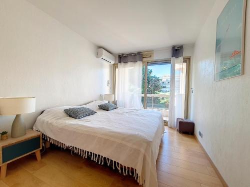 une chambre avec un lit et une grande fenêtre dans l'établissement L'Écrin de la Rostagne, à Antibes