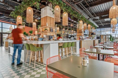 a man standing at a counter in a restaurant at Mercure Paris Orly Airport in Orly