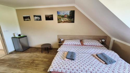 a bedroom with two beds and pictures on the wall at Penzion a restaurace Zlatovláska u zámku Červená Lhota in Jižná