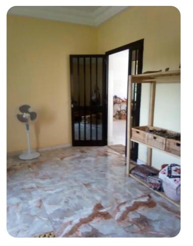 an empty room with a glass door and a stone floor at Maison Manour, suite, salon, bain privée in Mbour