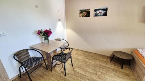 a room with a table and chairs and a vase of flowers at Penzion a restaurace Zlatovláska u zámku Červená Lhota in Jižná
