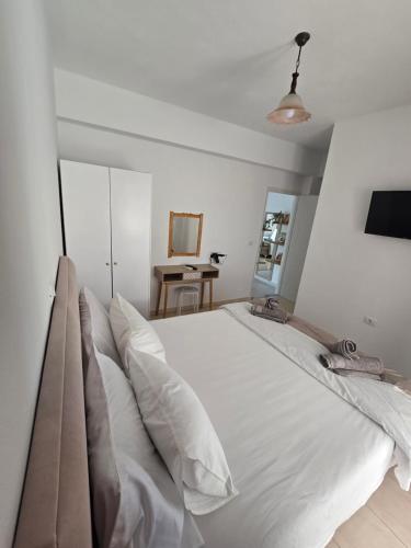 a bedroom with a large white bed with pillows at Villa Papa in Ksamil