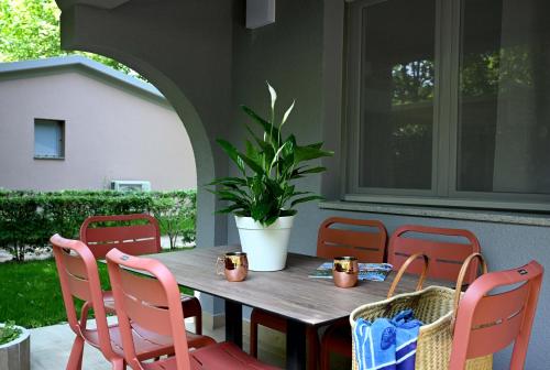 a table and chairs on a porch with a potted plant at Camping Village Baia Azzurra in Castiglione della Pescaia