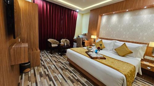 a hotel room with a large bed and a desk at The Royal Bihar in Patna