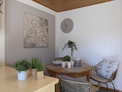 a room with a table and a clock on the wall at Ferienhaus zur Altmühl - Ferienwohnungen & Gartenhäuser in Ornbau